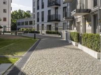 an empty cobblestone street between two multi -story buildings in a city