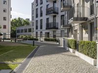 an empty cobblestone street between two multi -story buildings in a city