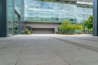 the empty concrete floor outside the large building where the doors are open and there is no people around