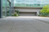 the empty concrete floor outside the large building where the doors are open and there is no people around