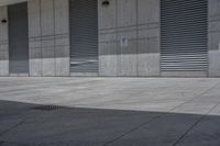 an empty concrete garage with lots of doors and shutters on it's walls