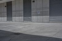 an empty concrete garage with lots of doors and shutters on it's walls