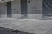 an empty concrete garage with lots of doors and shutters on it's walls