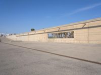 the empty concrete ramp at an airport with buildings in the background on either side of the road