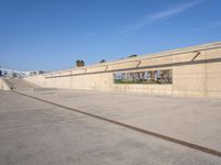 the empty concrete ramp at an airport with buildings in the background on either side of the road