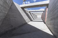 empty concrete ramp with sky and cloud in background, seen from inside the tunnel of a house