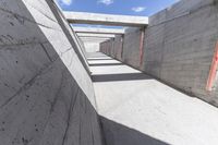 empty concrete ramp with sky and cloud in background, seen from inside the tunnel of a house