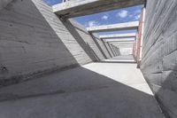 empty concrete ramp with sky and cloud in background, seen from inside the tunnel of a house