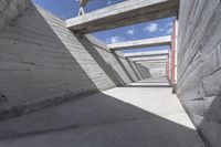 empty concrete ramp with sky and cloud in background, seen from inside the tunnel of a house