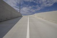 long empty concrete road under blue sky, with light traffic lane, on the right bank