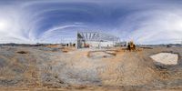 a wide angle view of an empty construction site with some machinery in it in the background