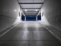 a white empty corridor at night with a bright blue sky in the background in a large metal storage building