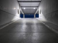 a white empty corridor at night with a bright blue sky in the background in a large metal storage building