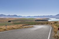 the road is empty on this big country road to nowhere in new zealand, with mountains in the distance