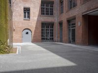 the courtyard is empty and there is only one person outside in this photo on the street