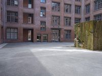 the courtyard is empty and there is only one person outside in this photo on the street