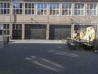 a view of an empty courtyard in the background is a window to an old factory with many glass windows