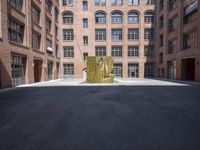 an empty courtyard with a bunch of windows in it in front of a building on the opposite side