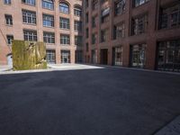 an empty courtyard with a bunch of windows in it in front of a building on the opposite side