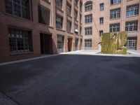 an empty courtyard with a bunch of windows in it in front of a building on the opposite side