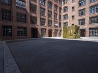 an empty courtyard with a bunch of windows in it in front of a building on the opposite side