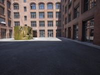 an empty courtyard with a bunch of windows in it in front of a building on the opposite side