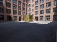 an empty courtyard with a bunch of windows in it in front of a building on the opposite side