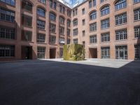 an empty courtyard with a bunch of windows in it in front of a building on the opposite side