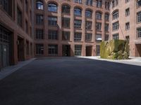 an empty courtyard with a bunch of windows in it in front of a building on the opposite side