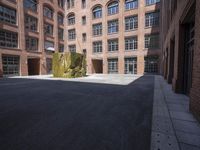 an empty courtyard with a bunch of windows in it in front of a building on the opposite side