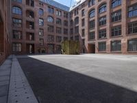 an empty courtyard with a bunch of windows in it in front of a building on the opposite side