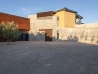 the courtyard at this modern house is empty of people, with one on fire hydrant near by