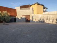 the courtyard at this modern house is empty of people, with one on fire hydrant near by