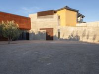 the courtyard at this modern house is empty of people, with one on fire hydrant near by