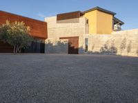 the courtyard at this modern house is empty of people, with one on fire hydrant near by