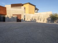 the courtyard at this modern house is empty of people, with one on fire hydrant near by