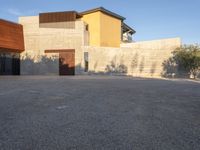 the courtyard at this modern house is empty of people, with one on fire hydrant near by