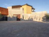 the courtyard at this modern house is empty of people, with one on fire hydrant near by