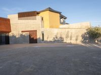 the courtyard at this modern house is empty of people, with one on fire hydrant near by