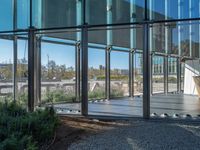 view of an empty patio from outside of building with high glass walls and wooden floors