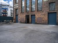 the empty courtyard with wooden tables and chairs is shown in a photograph with red brick walls