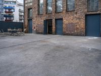 the empty courtyard with wooden tables and chairs is shown in a photograph with red brick walls