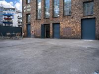 the empty courtyard with wooden tables and chairs is shown in a photograph with red brick walls