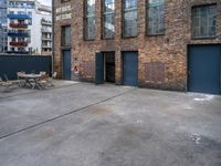 the empty courtyard with wooden tables and chairs is shown in a photograph with red brick walls