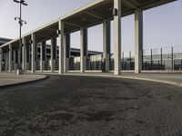 the curved asphalt pathway is empty and concreted near the station entrance of an industrial building