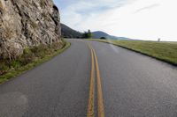 a road on the side of a mountain that is empty and curved away from it