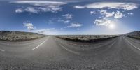 two road splits in the middle of an empty desert plain as the sun rises above