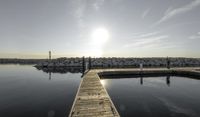 the dock is empty with rocks in the background as the sun is setting over the water