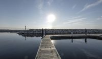 the dock is empty with rocks in the background as the sun is setting over the water