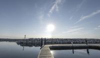 the dock is empty with rocks in the background as the sun is setting over the water